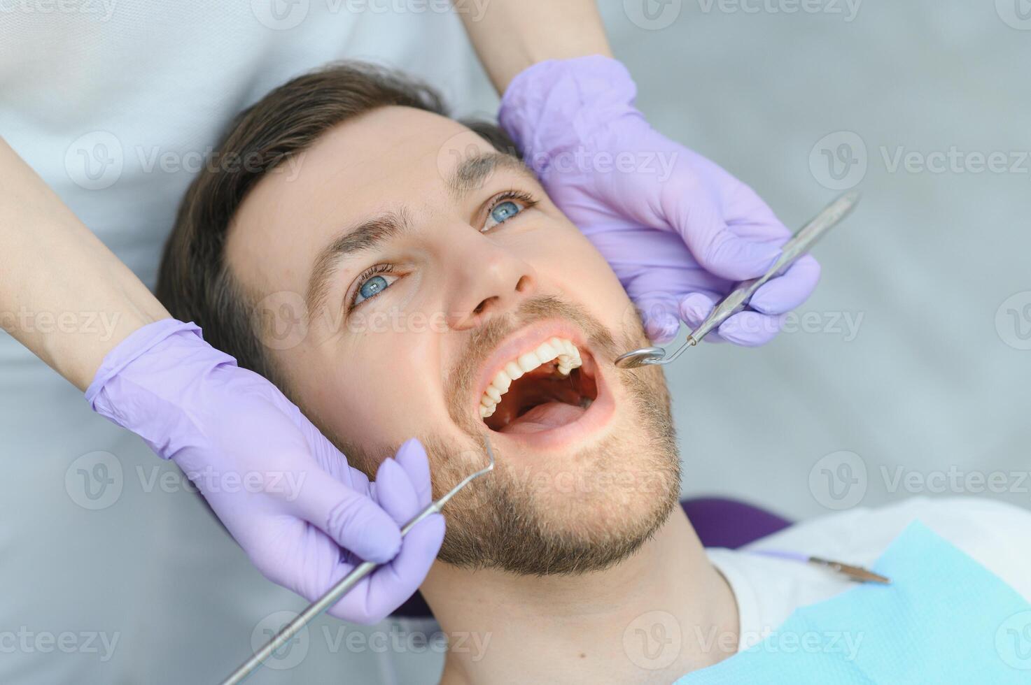 Young man at the dentist. Dental care, taking care of teeth. Picture with copy space for background. photo