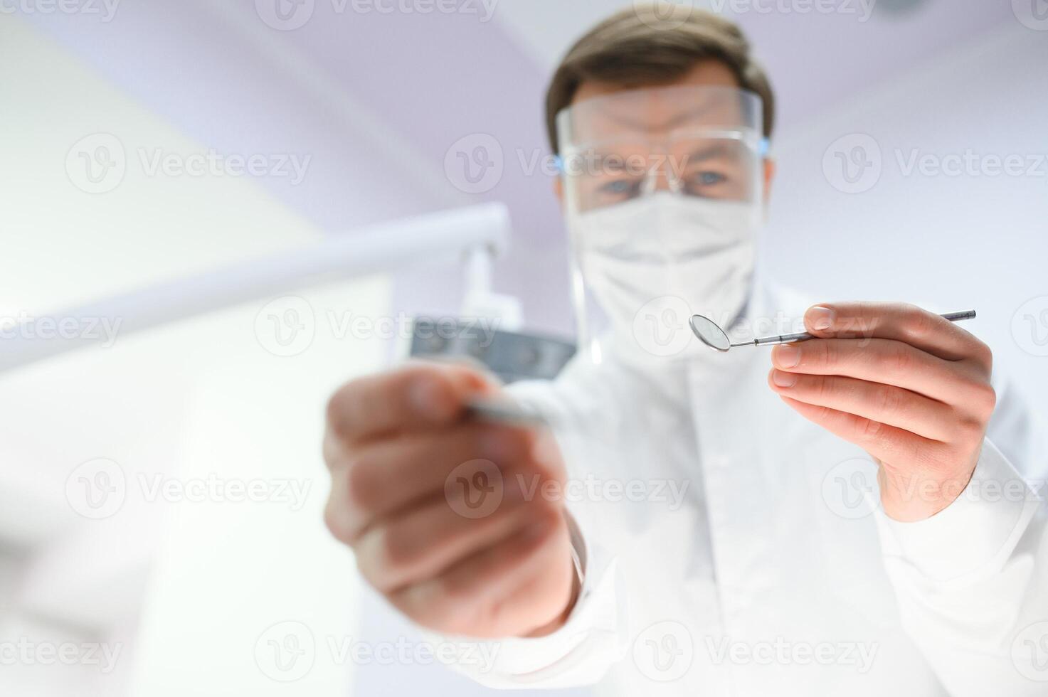 Bottom view. Dentist man with a tool in his hand. photo