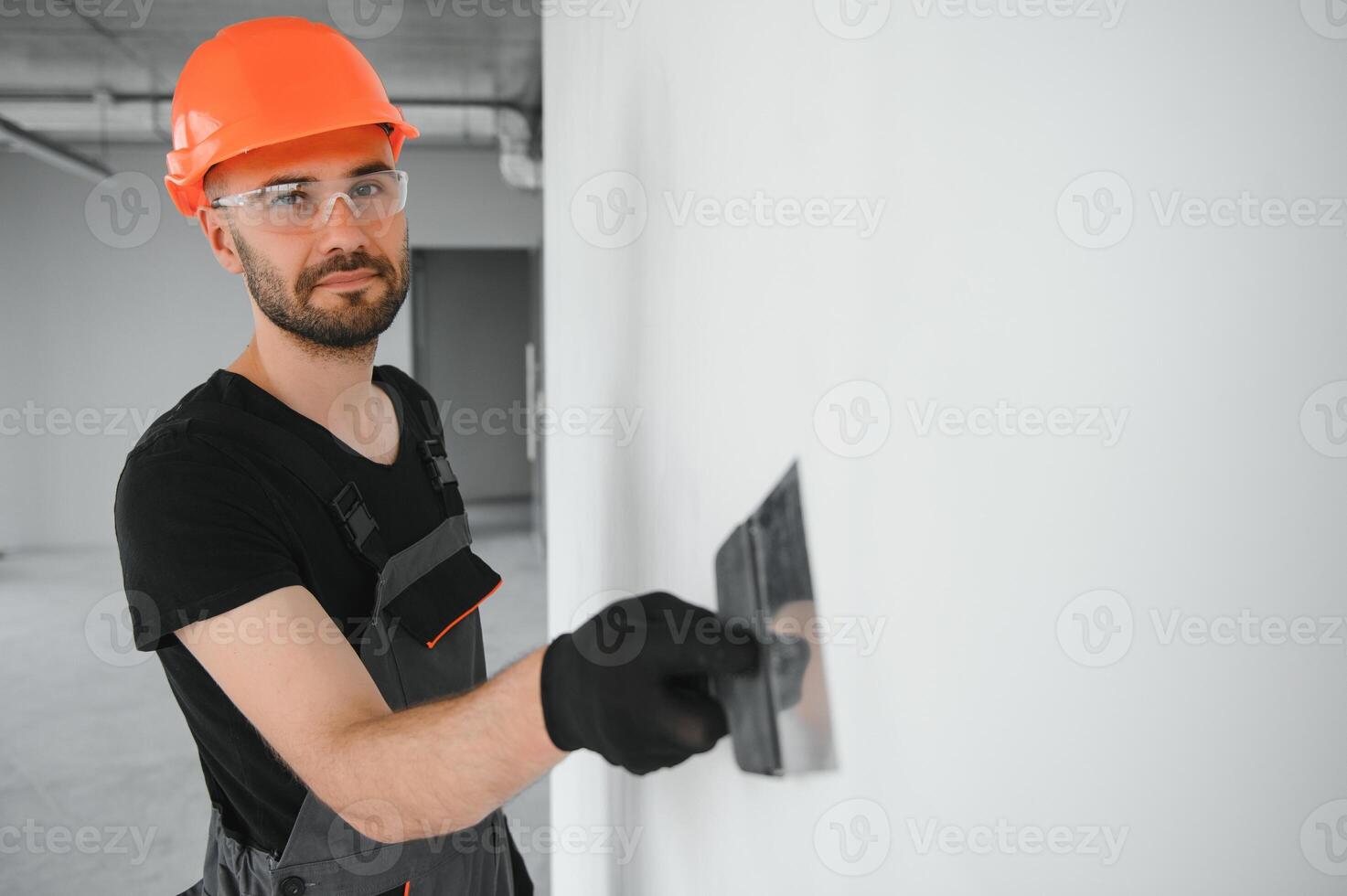 man drywall worker or plasterer putting mesh tape for plasterboard on a wall using a spatula and plaster. photo