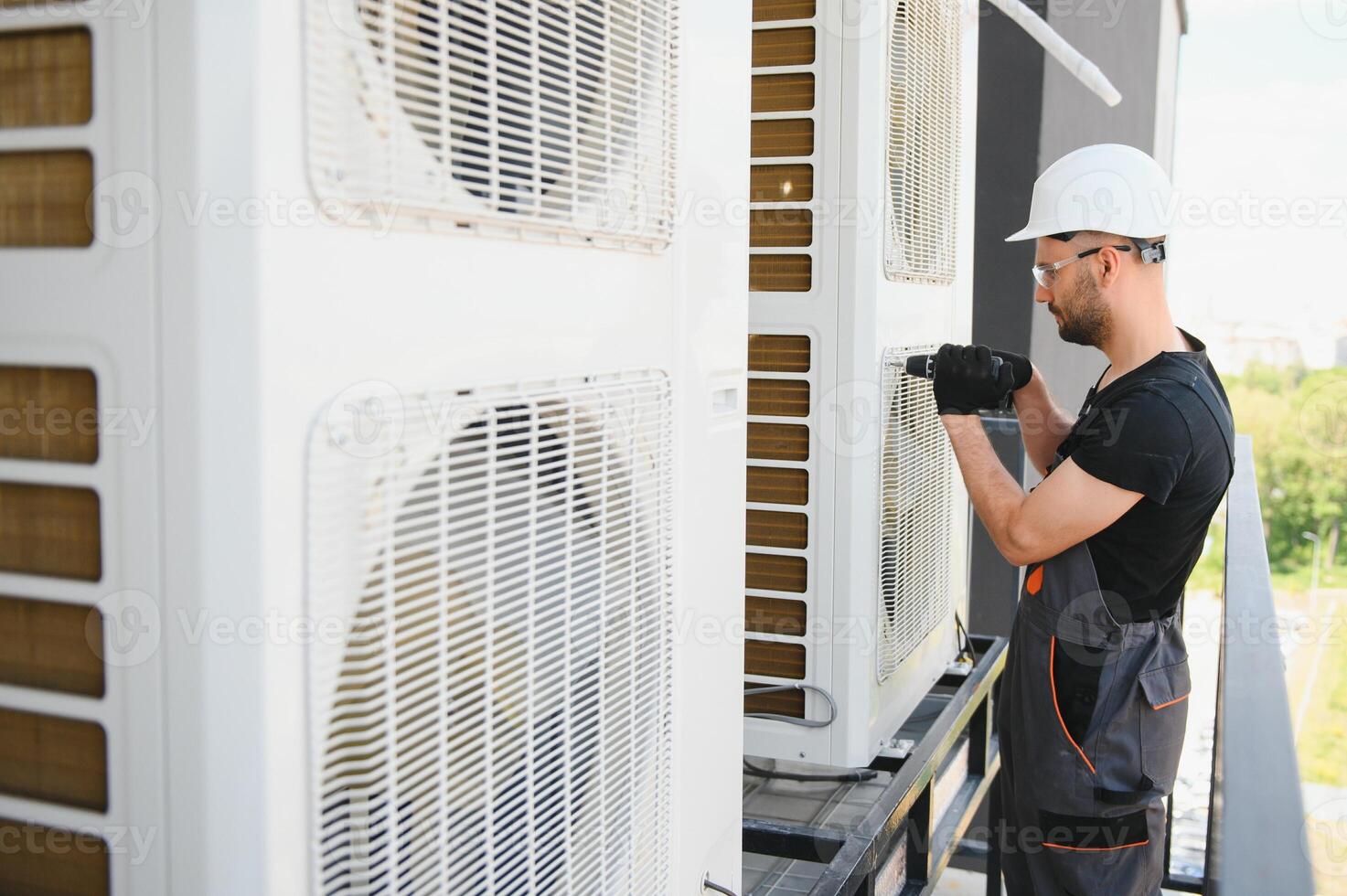 technician working on air conditioning or heat pump outdoor unit. HVAC service, maintenance and repair photo