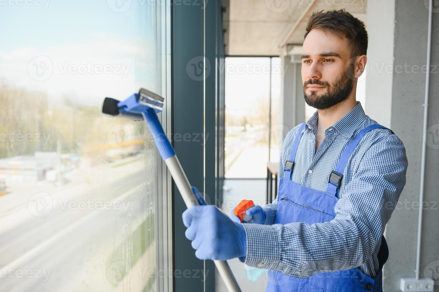 Male worker washing window glass. photo