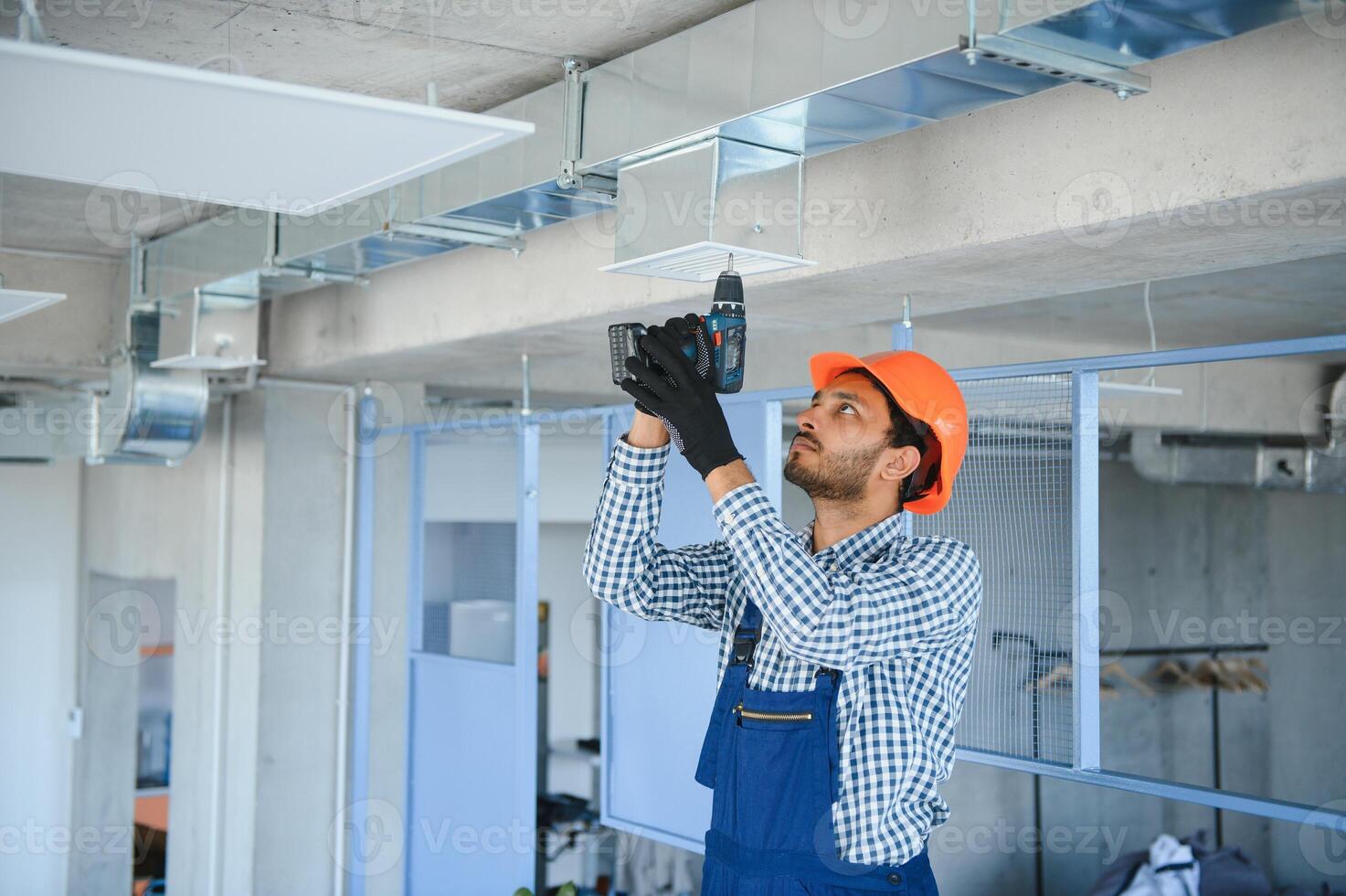 hvac indian worker install ducted pipe system for ventilation and air conditioning. copy space photo