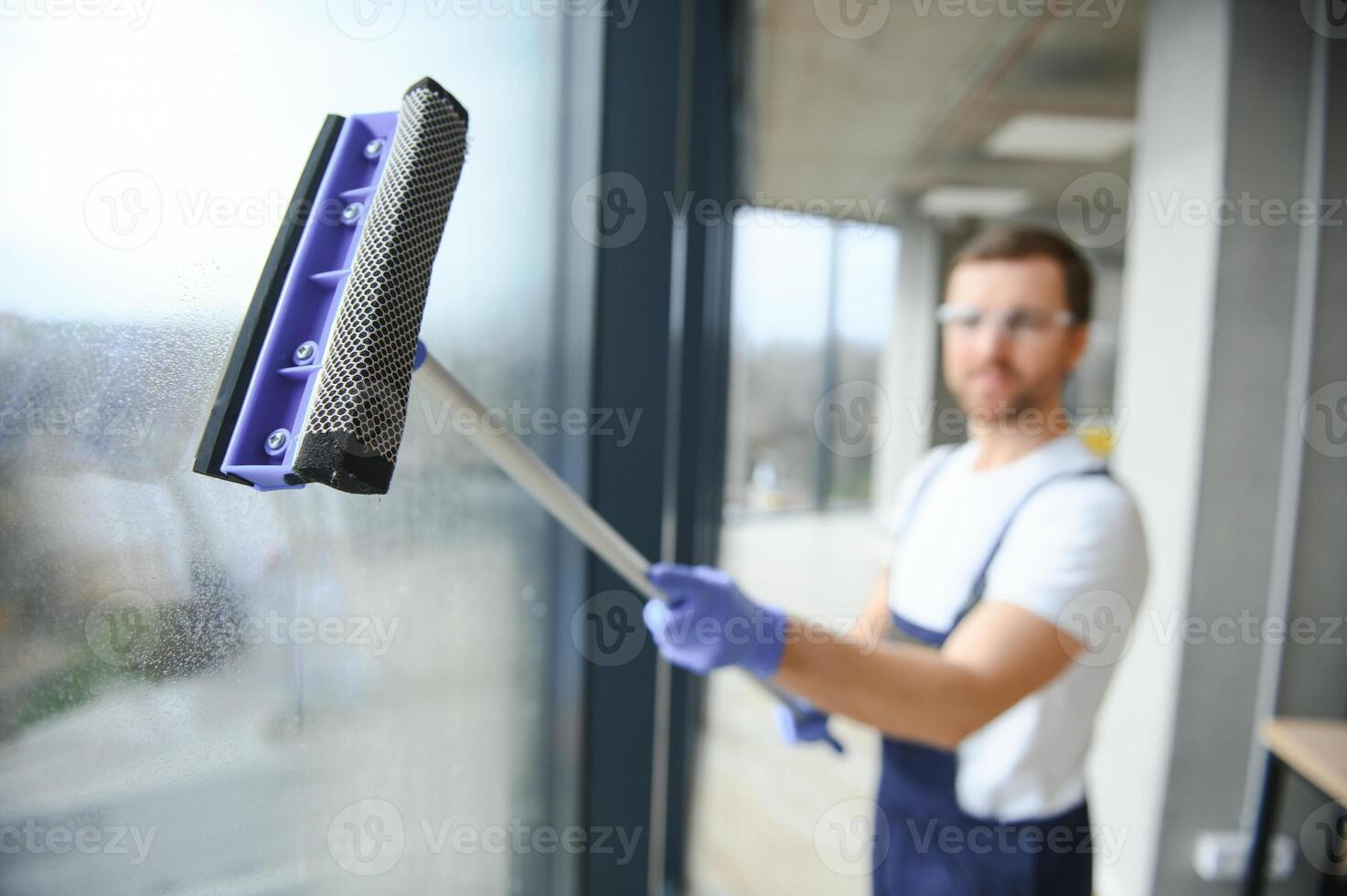An employee of a professional cleaning service washes the glass of the windows of the building. Showcase cleaning for shops and businesses. photo