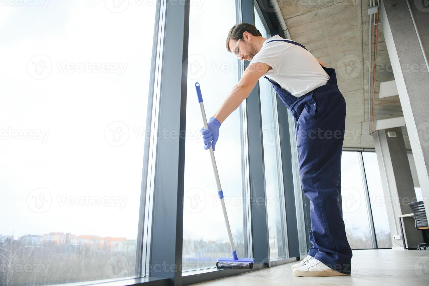 An employee of a professional cleaning service washes the glass of the windows of the building. Showcase cleaning for shops and businesses. photo