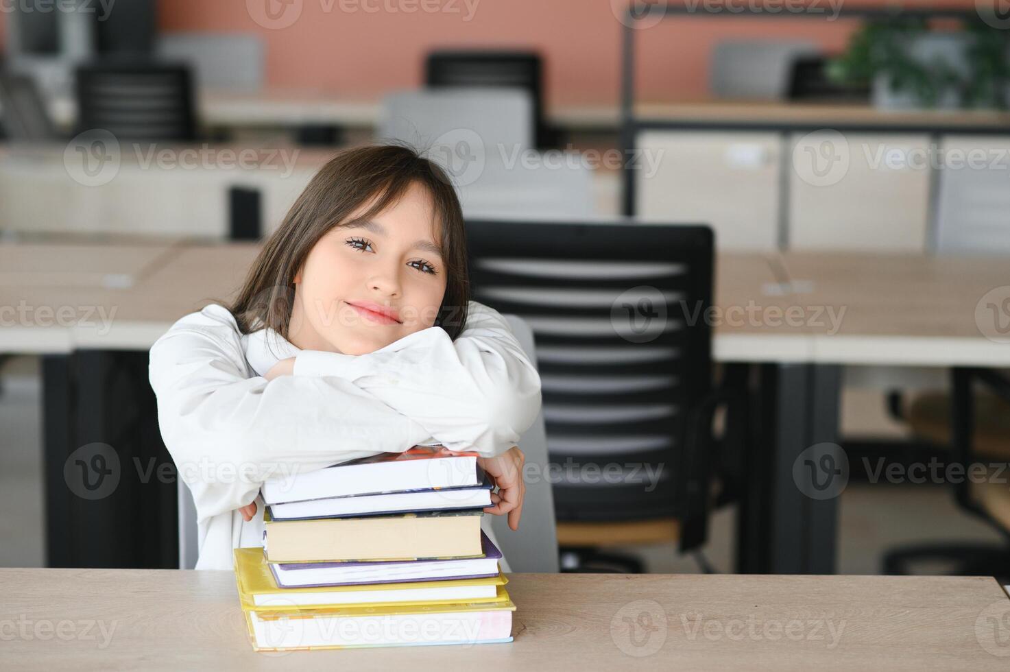 Teen girl studying with textbook writing essay learning in classroom. photo