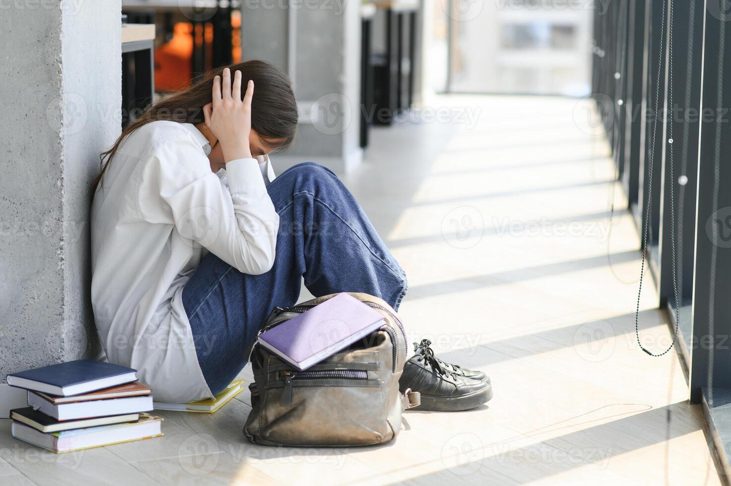 Lonely sad schoolgirl while all her classmates ignored her. Social exclusion problem. Bullying at school concept. photo