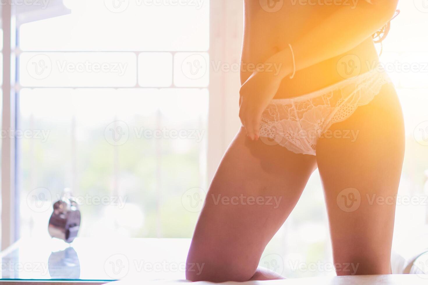 A young woman stood by the window in the morning after waking up to admire the view and atmosphere of the resort the morning after she had rested all night. Refreshing concept after waking up photo