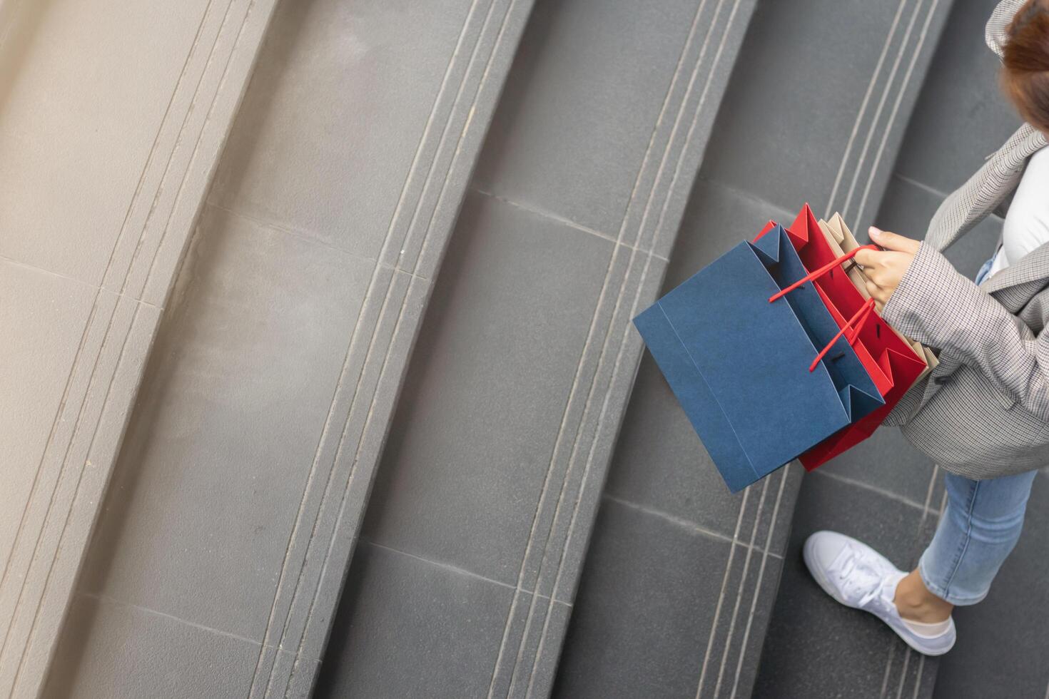 Blurred image, young woman holding a shopping bag after going shopping for discounted items in a department store as the New Year's holiday approaches, there is a promotion on sale. shopping concept photo
