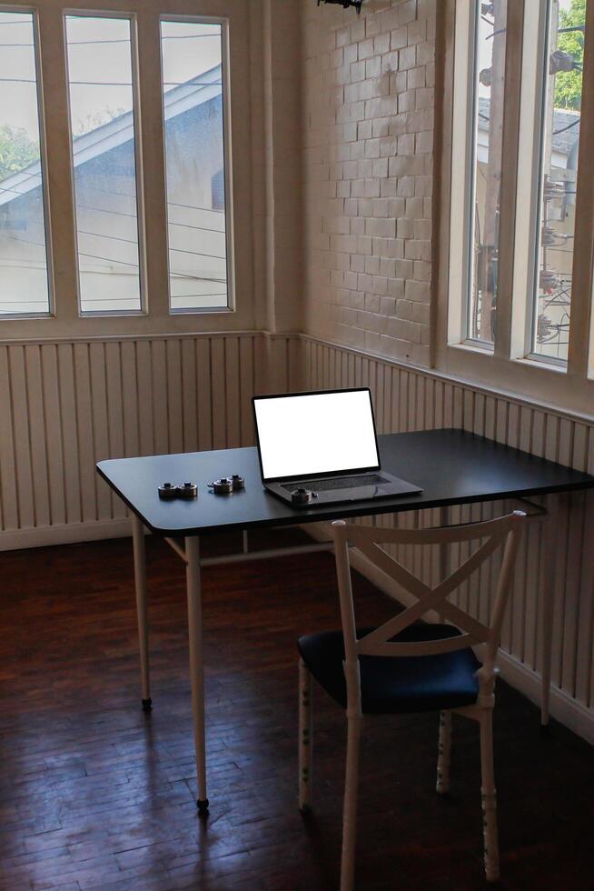 A notebook computer and a combination lock are placed on a black table. A hacker's notebook computer that prepares to compromise the target's system to steal sensitive information. photo