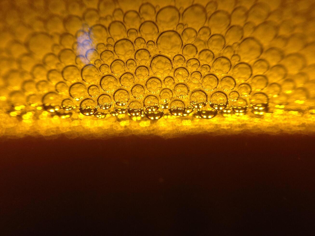 The backdrop and blurred background of the golden beer bubbles poured into the glass creates a large number of beer bubbles rising above the beer below. Copy Space for text design work photo