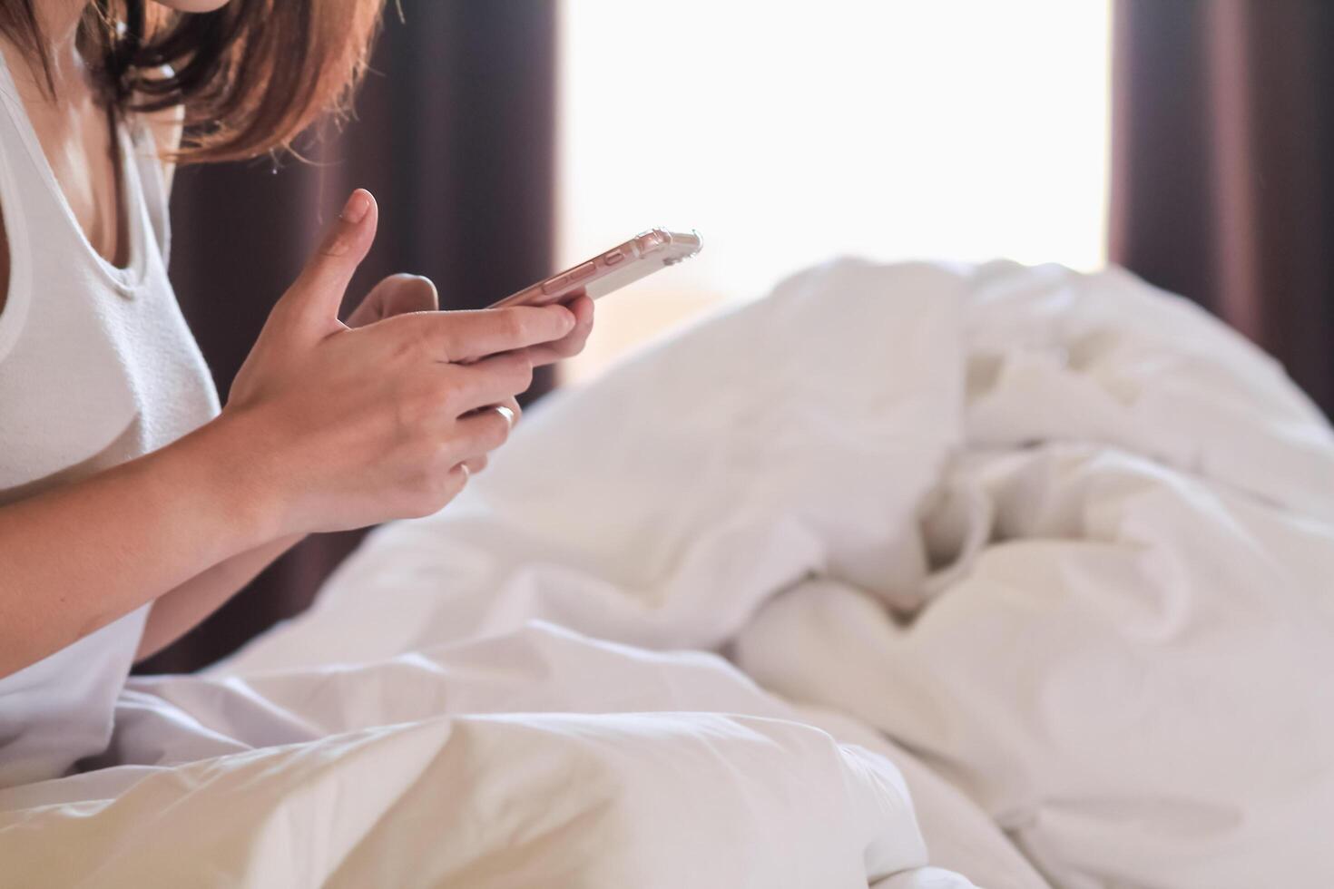 Soft And Smooth Focus,The woman works at home and wakes up in the bedroom with a mobile phone to check the job queue and respond to messages with clients and colleagues who are also working at home. photo