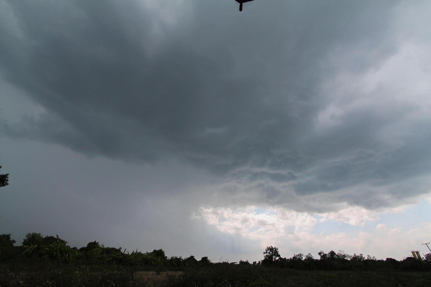Black clouds in the sky in the rainy season are the formations of a rain storm in the evening. The background of the sky full of black dark rain clouds photo