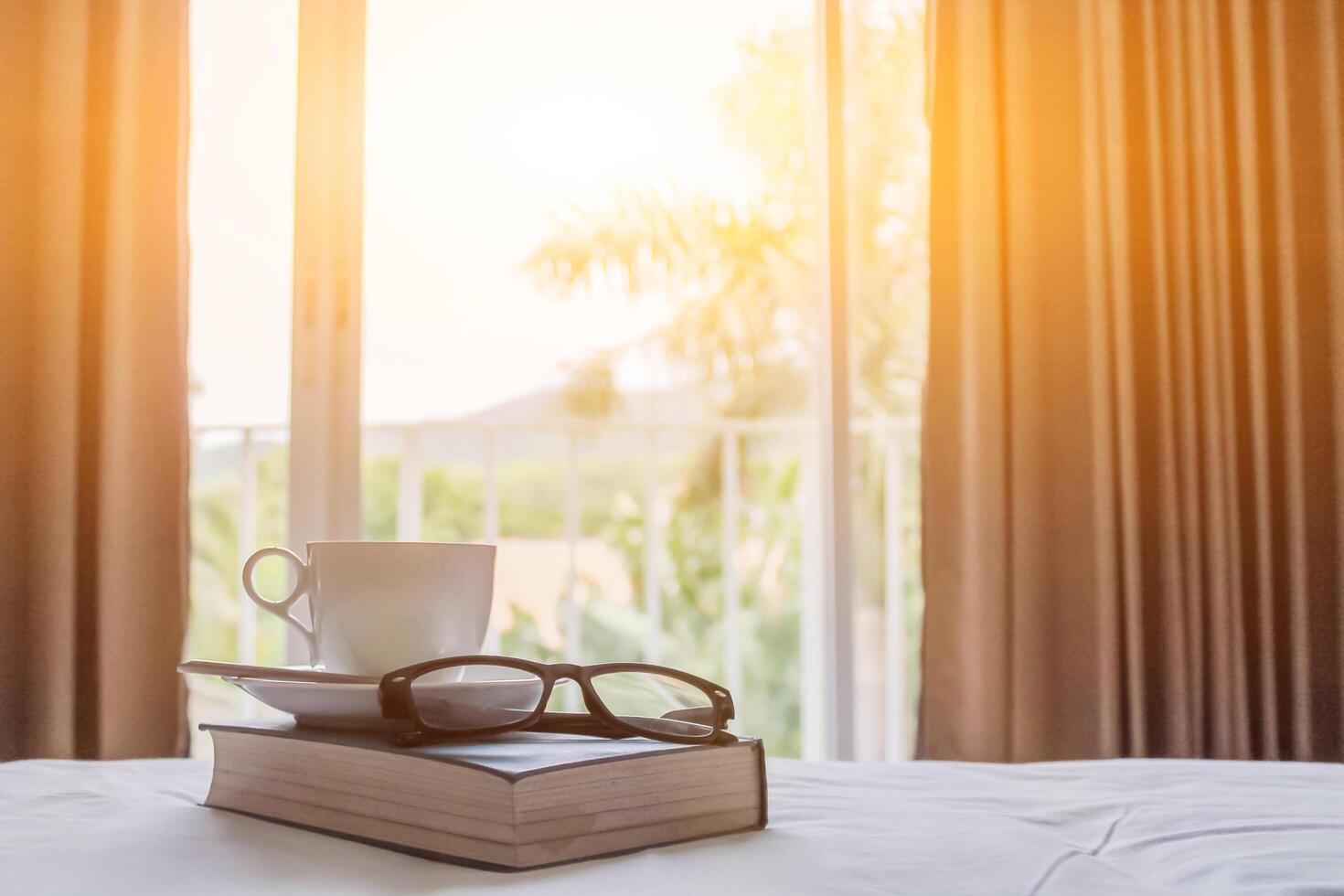 hot coffee cup that was placed next to the Bible in the morning was prepared to learn and study the scriptures while drinking coffee. The concept of learning the teachings of God through the Bible. photo
