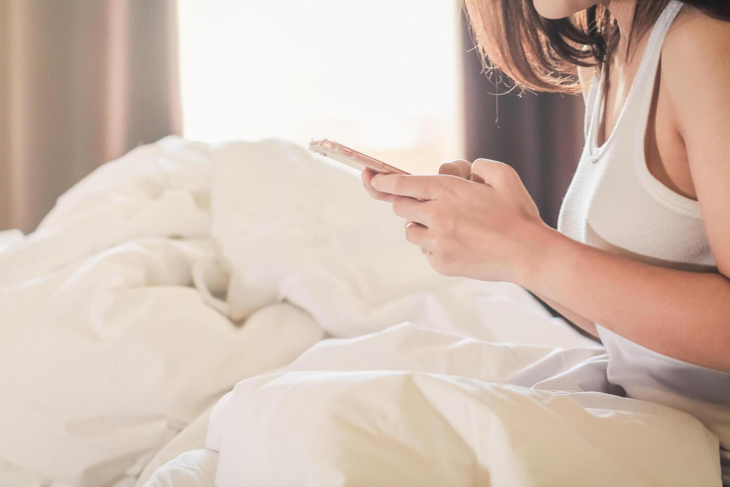 Soft And Smooth Focus,The woman works at home and wakes up in the bedroom with a mobile phone to check the job queue and respond to messages with clients and colleagues who are also working at home. photo