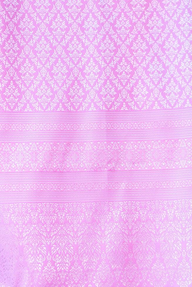 Thai silk with beautiful patterns and a high price because silk is added using ancient methods to produce fibers and weaving with ancient weaving machines resulting in beautiful patterned silk. photo