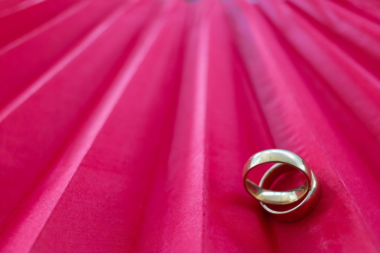 Two gold rings for couples prepared to be given to each other on Valentine's Day on a red background and two gold rings also symbolize promise between lovers to love and care for each other forever. photo