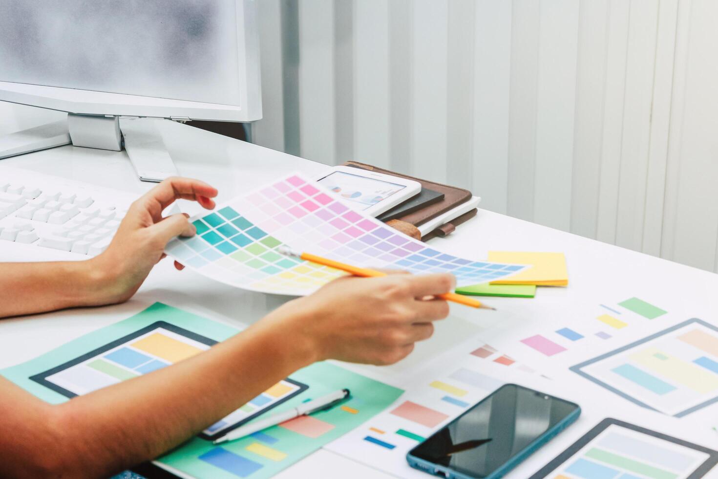 A Designer team and website designers are collaborating to develop a website using the ux ui system to match with the smartphone system. Ux ui system learning concepts for application development photo