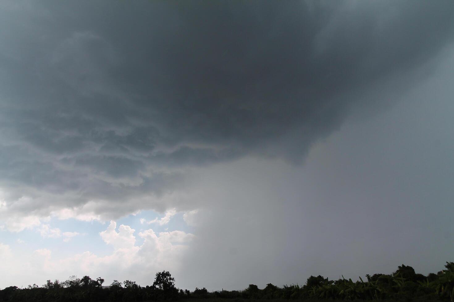 Black clouds in the sky in the rainy season are the formations of a rain storm in the evening. The background of the sky full of black dark rain clouds photo