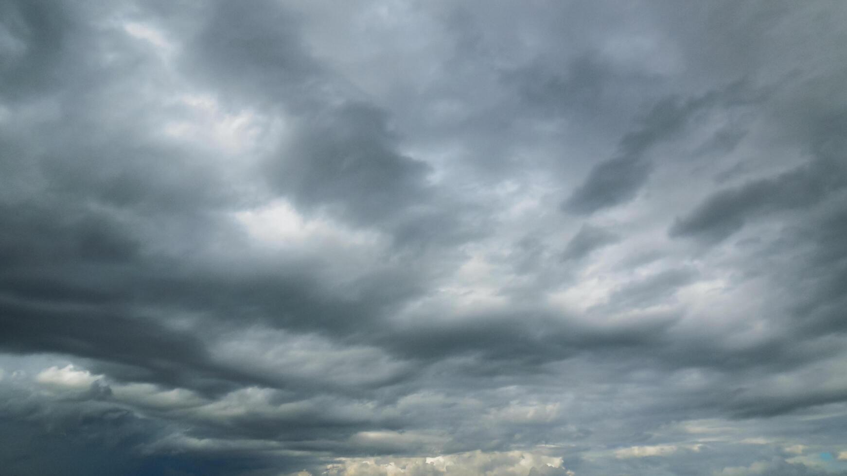 The rain clouds that are forming above the sky are rain clouds of the storms that are bringing moisture into the seasonal areas. The background of the sky is full of black clouds from thunderstorm photo