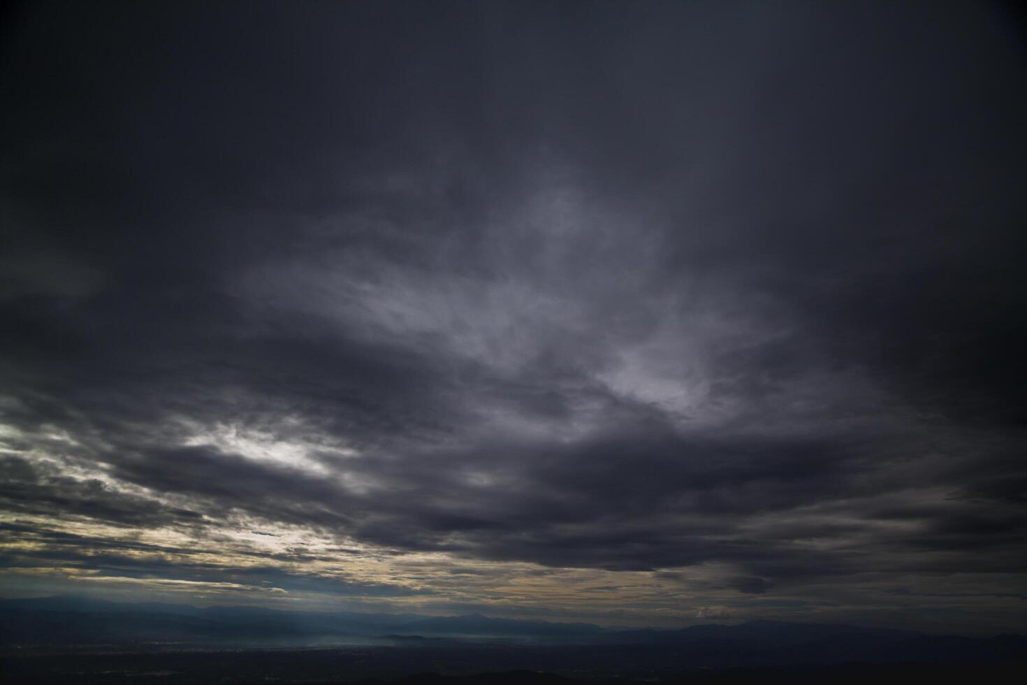 The rain clouds that are forming above the sky are rain clouds of the storms that are bringing moisture into the seasonal areas. The background of the sky is full of black clouds from thunderstorm photo