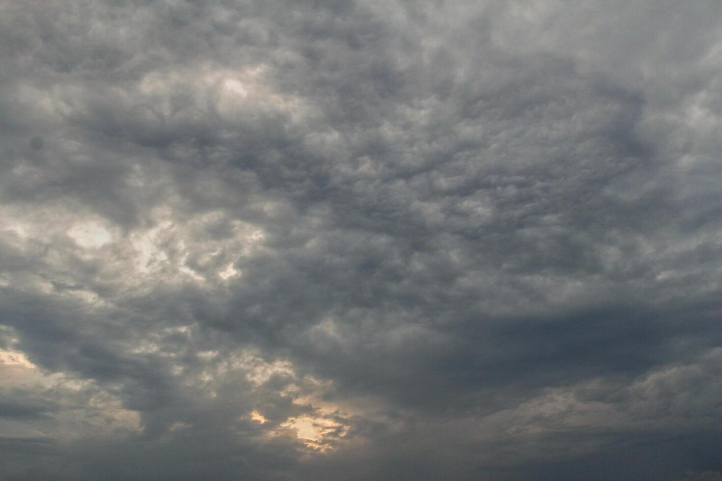 Black clouds in the sky in the rainy season are the formations of a rain storm in the evening. The background of the sky full of black dark rain clouds photo