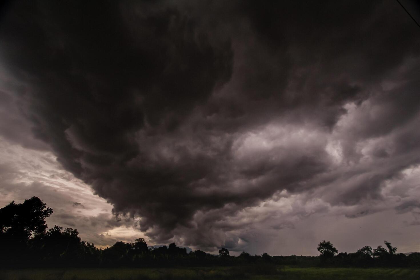 The rain clouds that are forming above the sky are rain clouds of the storms that are bringing moisture into the seasonal areas. The background of the sky is full of black clouds from thunderstorm photo