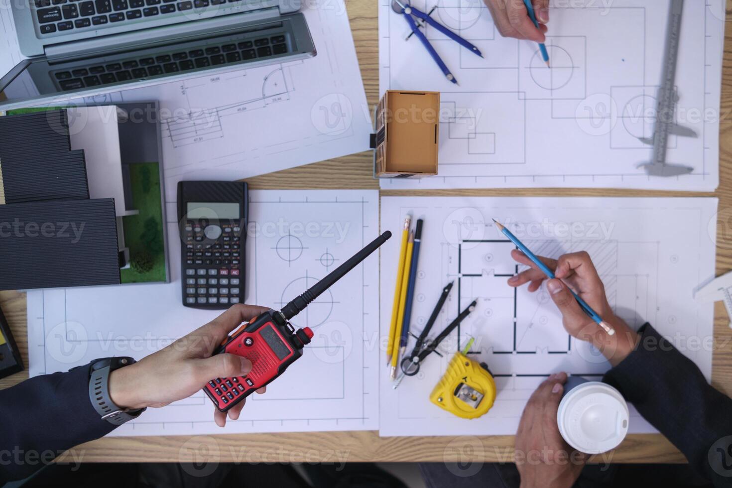 A team of engineers and architects discuss house plan design and estimate construction prices to suit the construction budget. Checking blueprints and documents with a team of engineers and architects photo