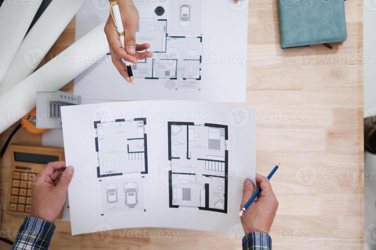 A team of engineers and architects discuss house plan design and estimate construction prices to suit the construction budget. Checking blueprints and documents with a team of engineers and architects photo