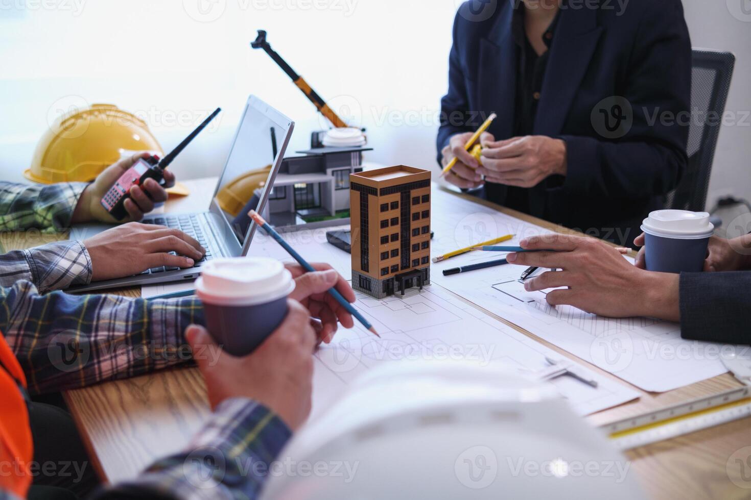 team of engineers and architects discuss house plan design and estimate construction prices to suit the construction budget. Checking blueprints and documents with a team of engineers and architects photo