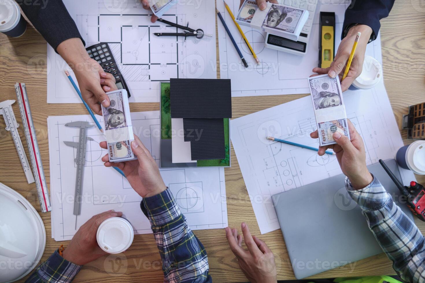 team of engineers and architects discuss house plan design and estimate construction prices to suit the construction budget. Checking blueprints and documents with a team of engineers and architects photo