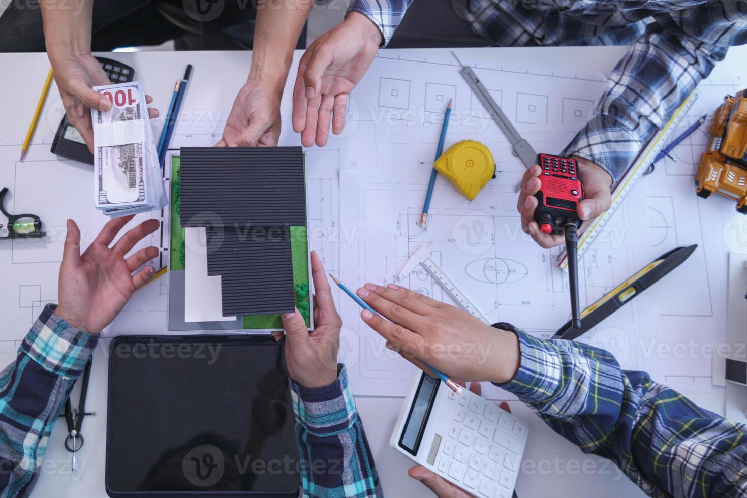 team of engineers and architects discuss house plan design and estimate construction prices to suit the construction budget. Checking blueprints and documents with a team of engineers and architects photo