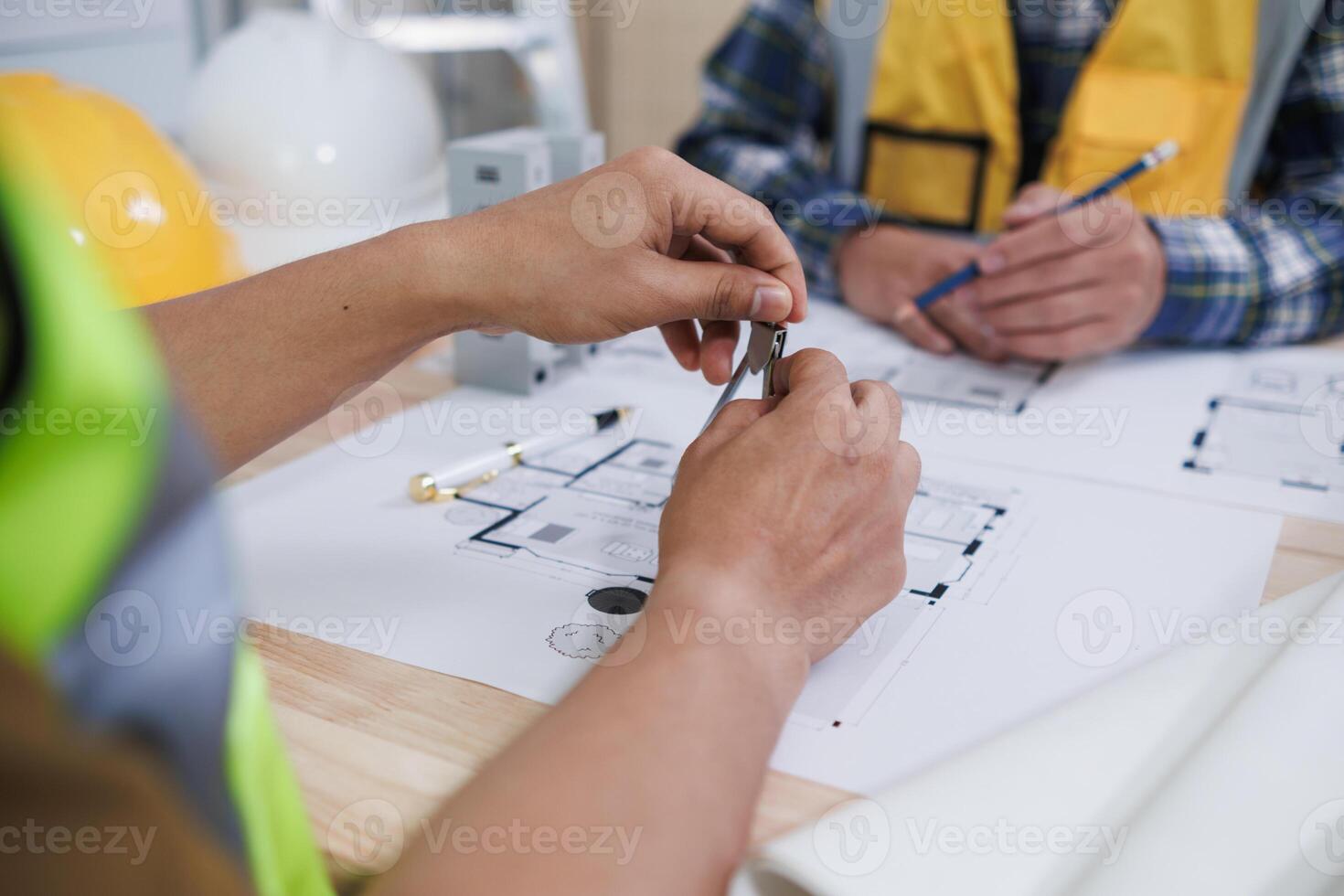 A team of engineers and architects discuss house plan design and estimate construction prices to suit the construction budget. Checking blueprints and documents with a team of engineers and architects photo