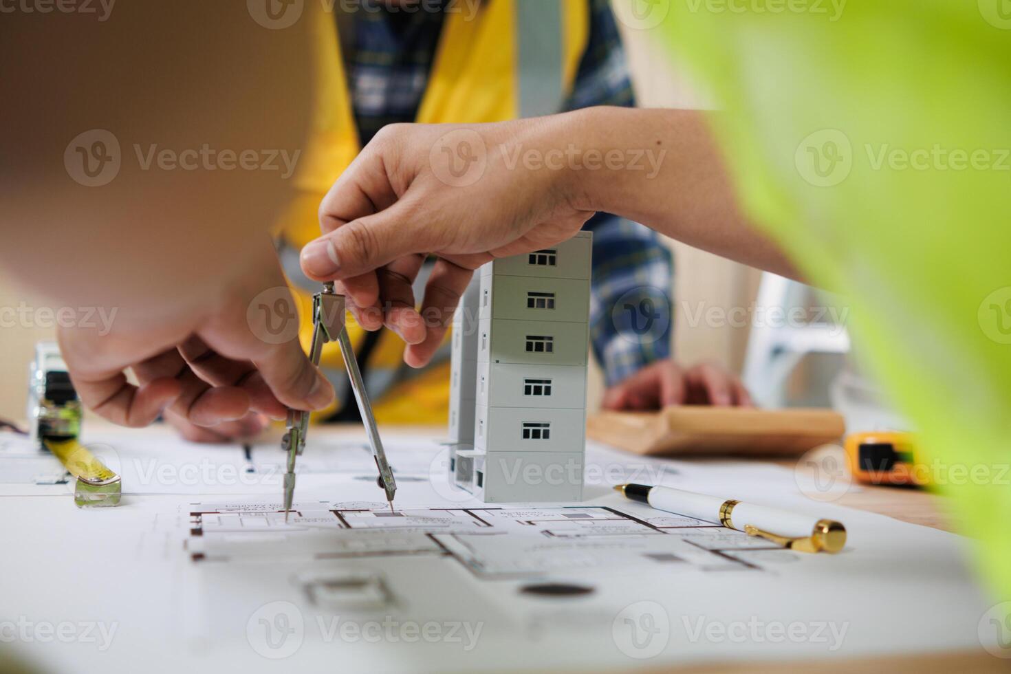 A team of engineers and architects discuss house plan design and estimate construction prices to suit the construction budget. Checking blueprints and documents with a team of engineers and architects photo