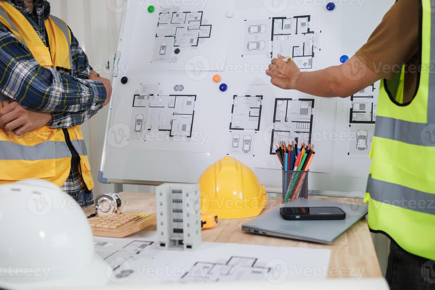 A team of engineers and architects discuss house plan design and estimate construction prices to suit the construction budget. Checking blueprints and documents with a team of engineers and architects photo