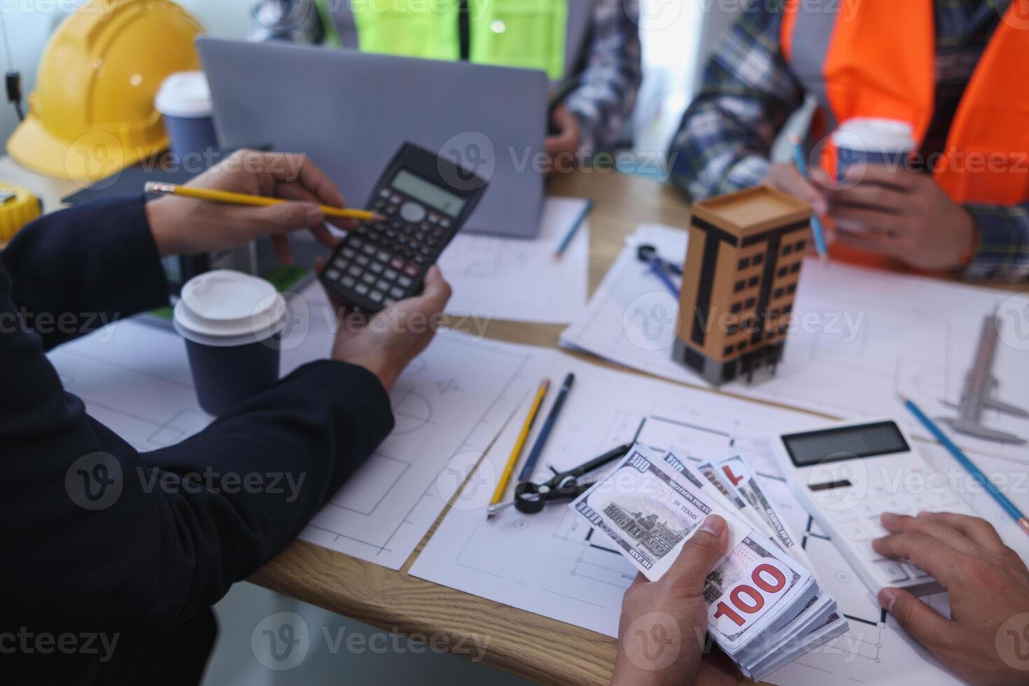 team of engineers and architects discuss house plan design and estimate construction prices to suit the construction budget. Checking blueprints and documents with a team of engineers and architects photo