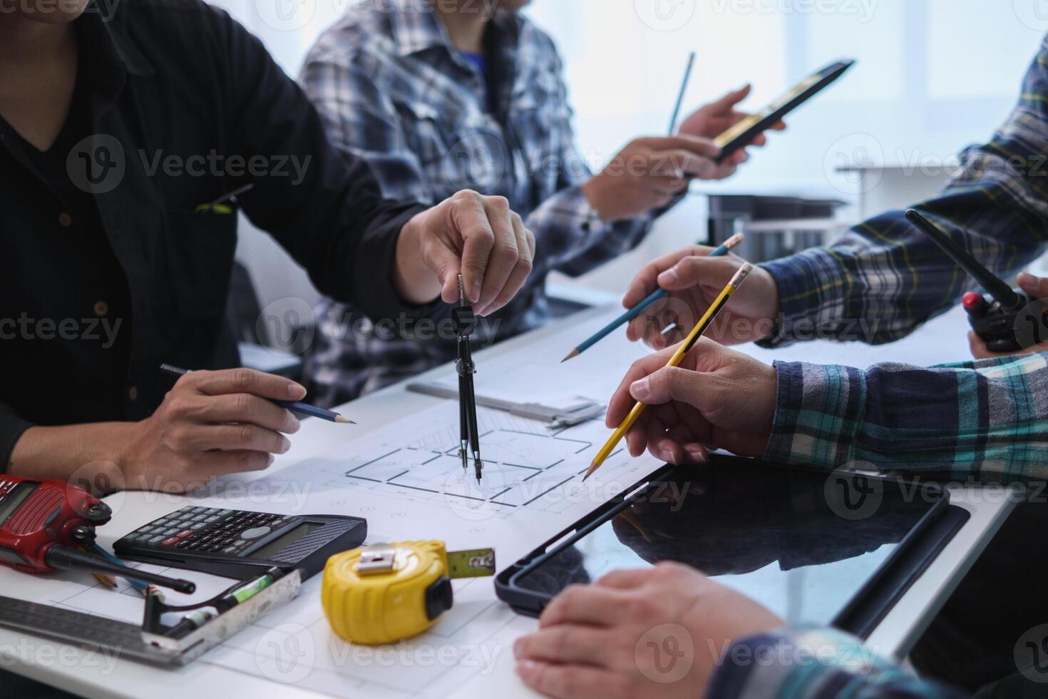 A team of engineers and architects discuss house plan design and estimate construction prices to suit the construction budget. Checking blueprints and documents with a team of engineers and architects photo