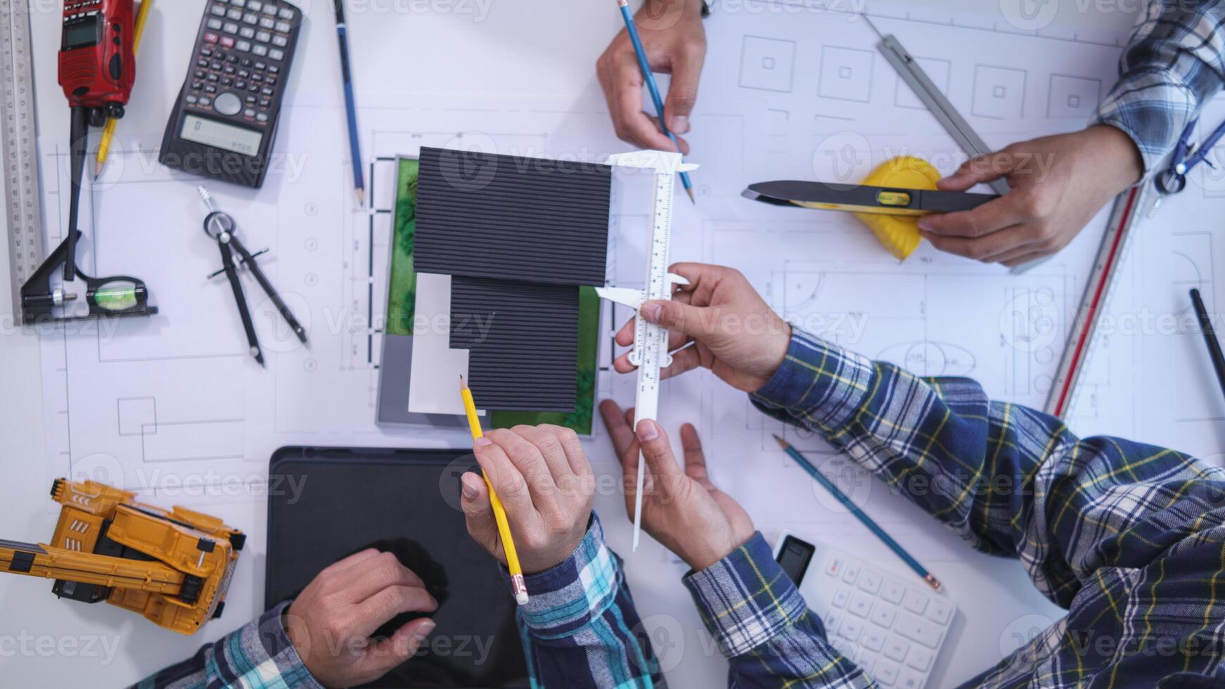 team of engineers and architects discuss house plan design and estimate construction prices to suit the construction budget. Checking blueprints and documents with a team of engineers and architects photo