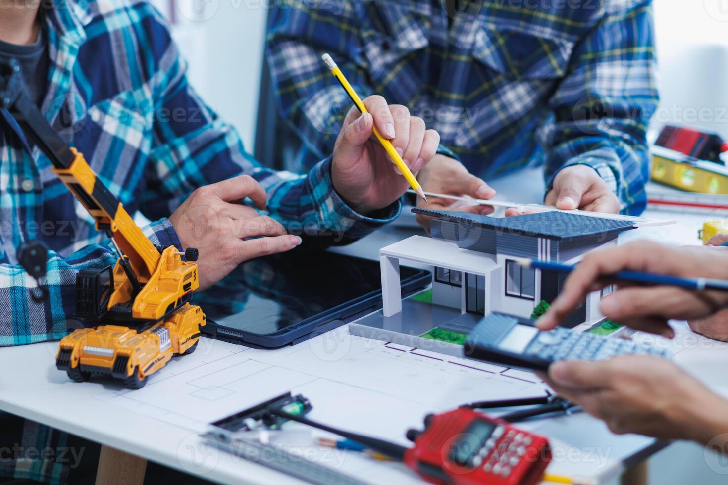 team of engineers and architects discuss house plan design and estimate construction prices to suit the construction budget. Checking blueprints and documents with a team of engineers and architects photo
