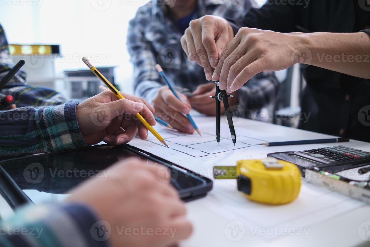 A team of engineers and architects discuss house plan design and estimate construction prices to suit the construction budget. Checking blueprints and documents with a team of engineers and architects photo
