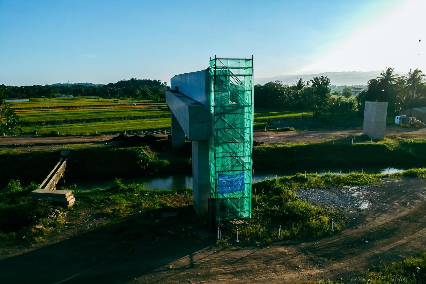 Sleman, Yogyakarta, Indonesia, 2024 - Toll road construction project over the Mataram ditch. A toll bridge is being built over the water flow so as not to displace rice fields and settlements photo