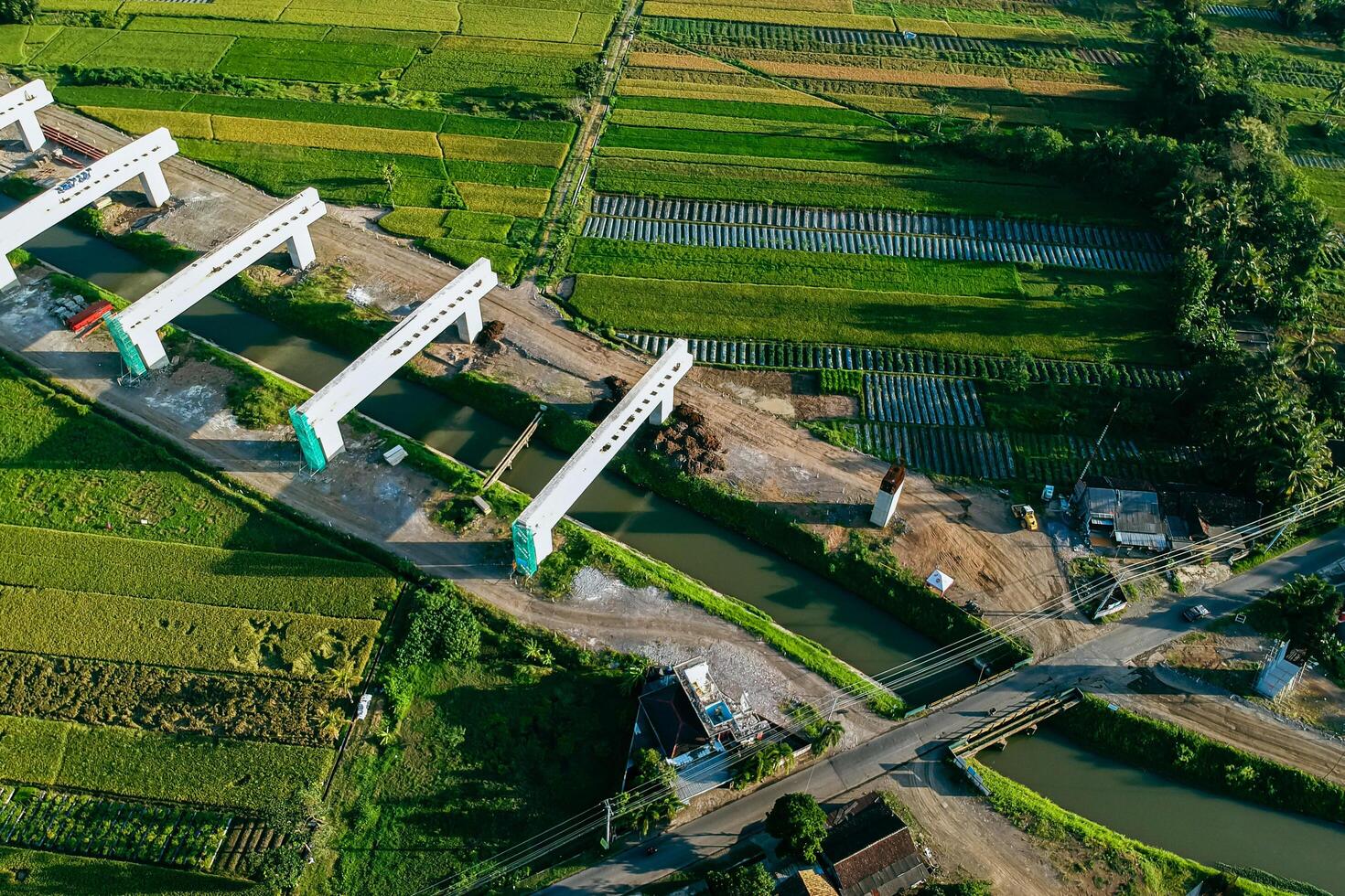 Sleman, Yogyakarta, Indonesia, 2024 - Toll road construction project over the Mataram ditch. A toll bridge is being built over the water flow so as not to displace rice fields and settlements photo