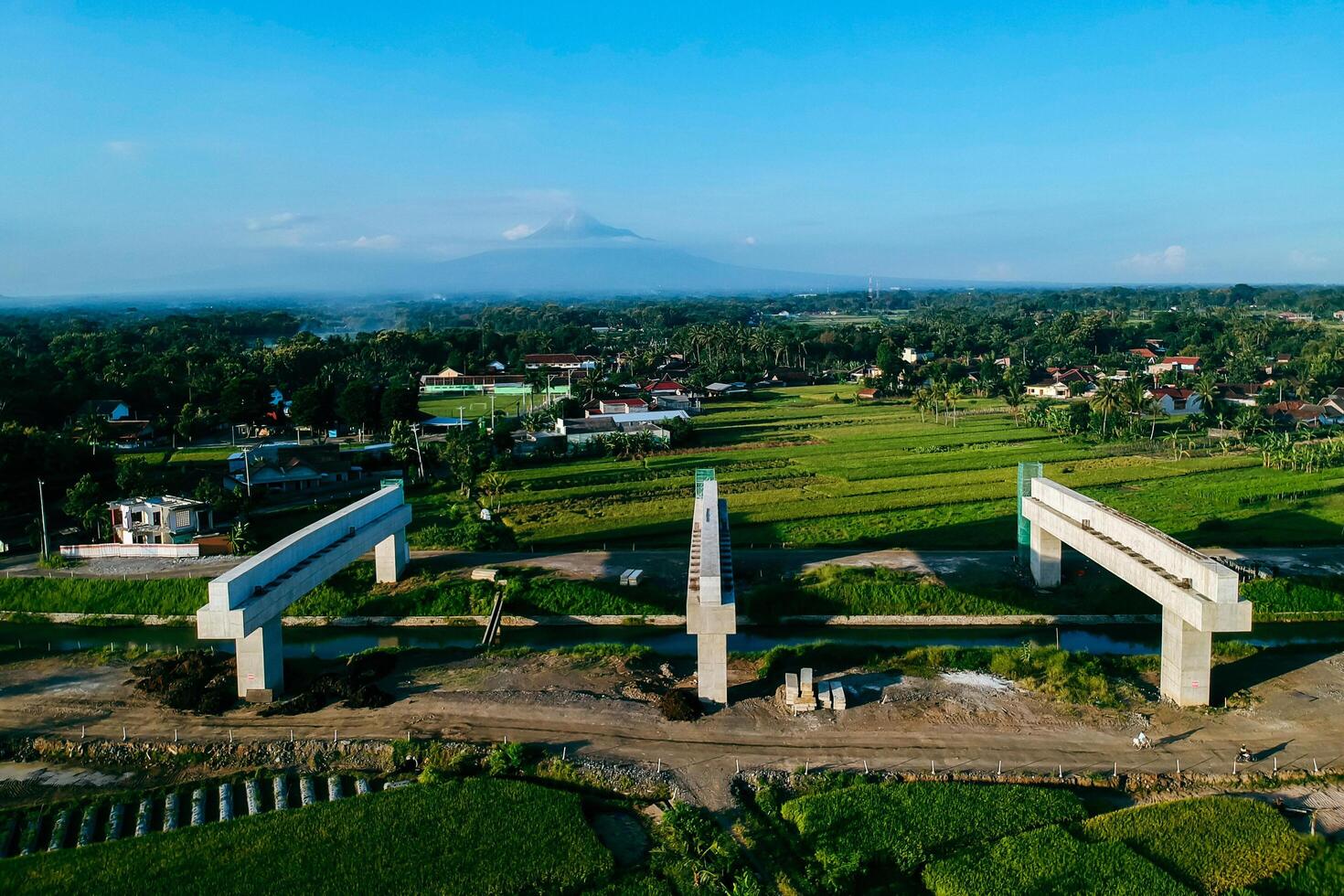 Sleman, Yogyakarta, Indonesia, 2024 - Toll road construction project over the Mataram ditch. A toll bridge is being built over the water flow so as not to displace rice fields and settlements photo