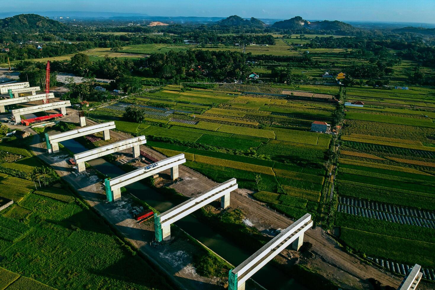 Sleman, Yogyakarta, Indonesia, 2024 - Toll road construction project over the Mataram ditch. A toll bridge is being built over the water flow so as not to displace rice fields and settlements photo