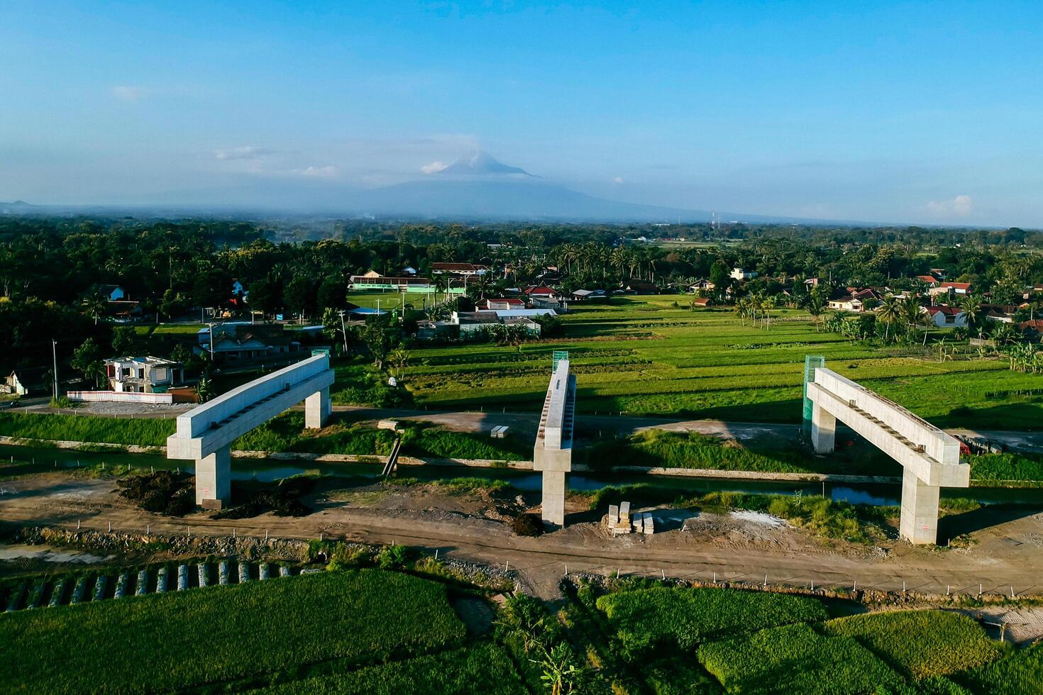 Sleman, Yogyakarta, Indonesia, 2024 - Toll road construction project over the Mataram ditch. A toll bridge is being built over the water flow so as not to displace rice fields and settlements photo