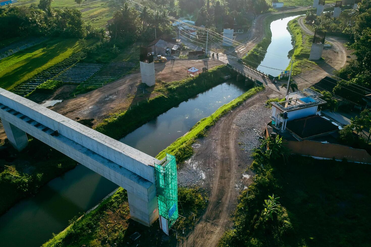 Sleman, Yogyakarta, Indonesia, 2024 - Toll road construction project over the Mataram ditch. A toll bridge is being built over the water flow so as not to displace rice fields and settlements photo
