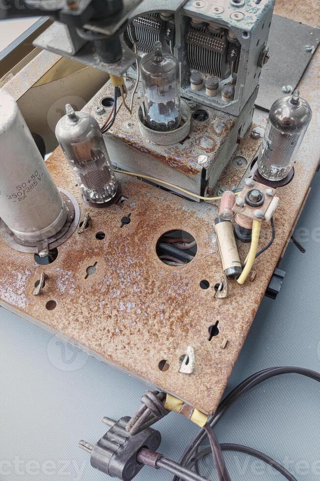 Parts of an old radio with traces of time. Radio tubes, transistors and so on. Rusty base photo