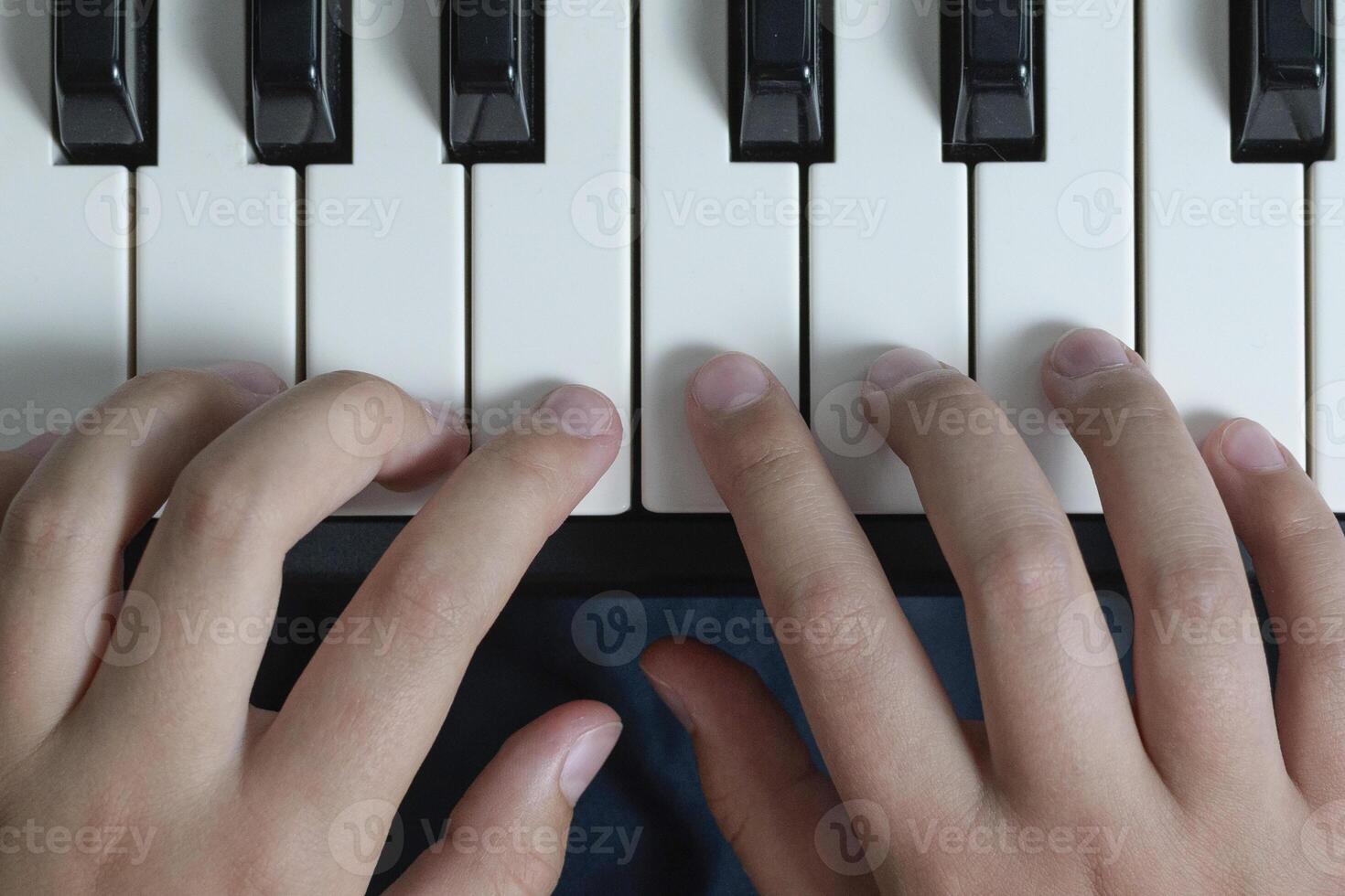 Piano chords and scales. Music exercises. Two hands playing. Close-up photo