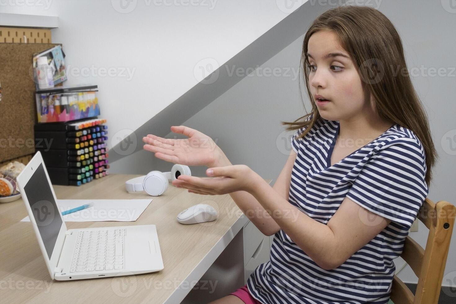 A teenage girl points to a broken computer. Homework not completed. Computer problem photo