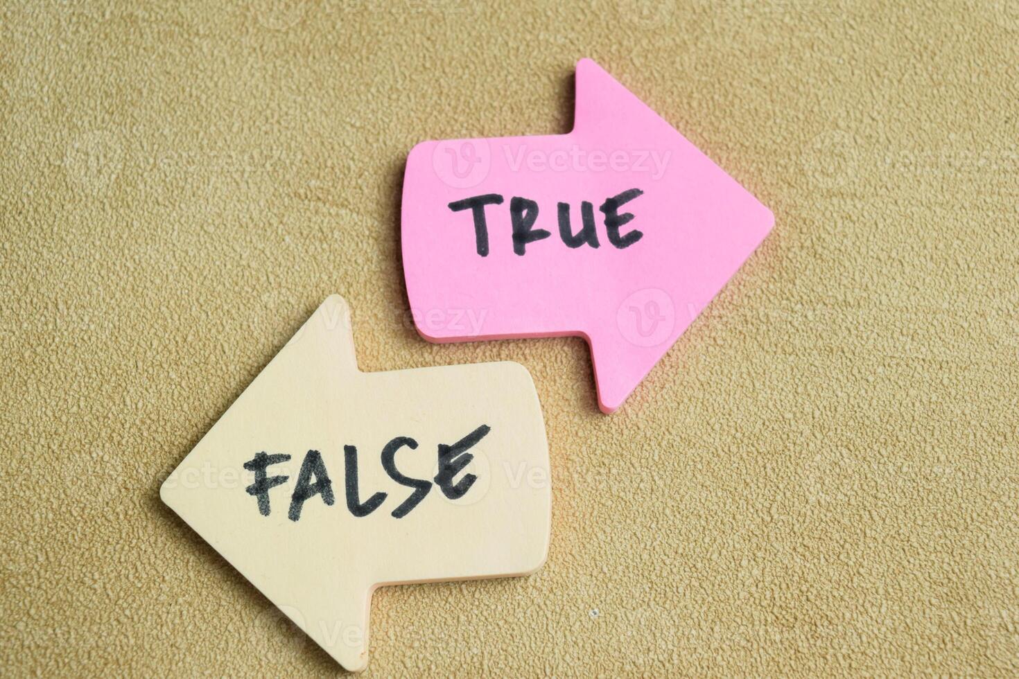 Concept of False or True write on sticky notes isolated on Wooden Table. photo