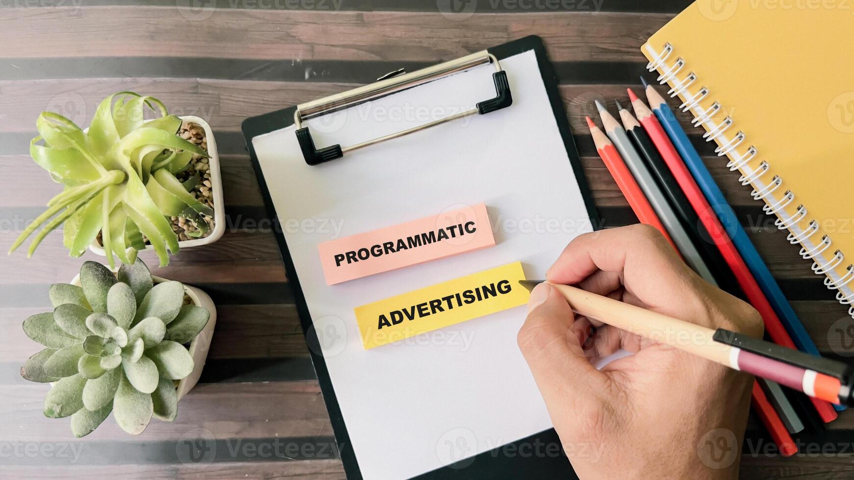 Concept of Programmatic Advertising write on sticky notes isolated on Wooden Table. photo